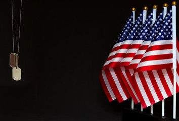 Desktop flags of USA and dog tags on black background with copy space. Concept of the Memorial and Veterans Day