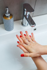 Wall Mural - White sink with a silver faucet in the bathroom. Gray can with liquid soap for hands. Turning on the tap water, personal hand hygiene. Hand washing under running water