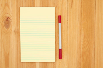 Wall Mural - Yellow legal lined notepad paper with a marker on pine wood desk