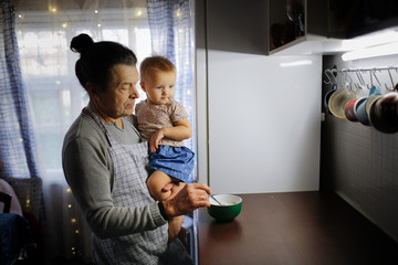 Wall Mural - man dad feeds baby porridge, dark style