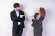 © Ivan - Man and woman standing side by side, pointing fingers at each other, business