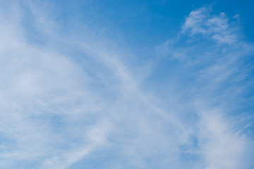 White clouds contrast with the blue sky on a bright sunny day. With warmth