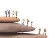 miniature people with  standing on rock on white background