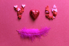 High Angle View Of Feather With Heart Shape Decoration On Table