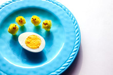 High Angle View Of Boiled Egg With Toy Baby Chickens In Plate