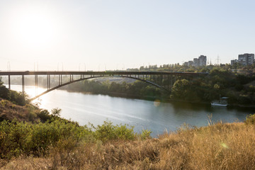 arch bridge over the river. autumn landscape at sunset. golden rays of light. golden hour.