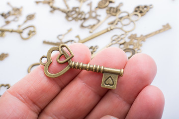 Heart shaped retro valentine metal key in hand