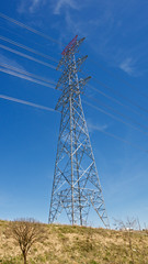 High voltage electrical tower. Electric poles in front of blue sky.