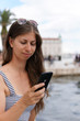 © ONEWORLD PICTURE - Kroatien, Dalmatien, Split, Altstadt, Frau an der Marina von Split, Sightseeing in Split, Handy, Social Media, Frau am Handy