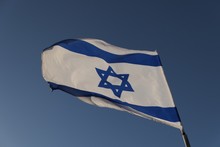 Low Angle View Of Israeli Flag Waving Against Clear Blue Sky
