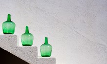 Close-up Of Green Bottles Against Wall