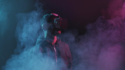 Wall Mural - Portrait of a man in virtual reality helmet. Obscured dark face in VR goggles. Internet, darknet, gaming and cyber simulation.