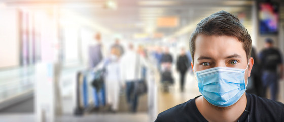 Airport young man tourist taking a flight in China wuhan wearing face mask. Coronavirus flu spread concept wide banner virus panorama