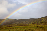 Fototapeta Tęcza - Iceland - August 15, 2017: The spectacullar rainbow arc on a hill near the Ring Road, Iceland, Europe