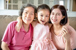 © Tom Wang - happy grandmother and daughter with granddaughter at home
