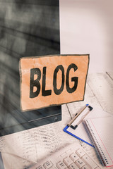 Poster - Word writing text Blog. Business photo showcasing regularly updated website web page run by individual Note paper taped to black computer screen near keyboard and stationary