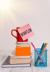 Fototapete - Writing note showing Workflow. Business concept for Series of activities or procedures necessary to complete a task Cup stacked note pad books on square box pens metal holder wooden table