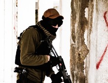 Terrorist With Gun Standing By Wall