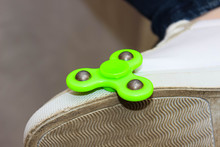 Green Spinner On The Foot Shod In Sneakers.