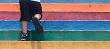Lower Part Of A Boy In Casual Shoe Walking Up Outdoor Colorful Stair,children Lifestyle Successful Concept