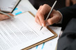 © H_Ko - Male arm in suit and tie fill form clipped pad with silver pen closeup. Sign gesture read pact sale agent bank job make note loan credit mortgage investment finance executive chief legal teamwork law