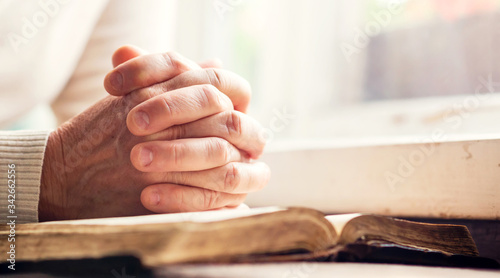 Fotomural Hands of a man praying over a Bible - represents faith and spirituality in every