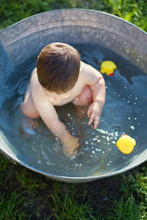 Little Baby Bathes In A Vintage Basin With Rubber Ducks