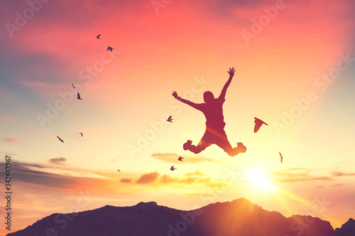 Cuadros en Lienzo Silhouette man jump and birds fly on sunset sky and cloud texture abstract background