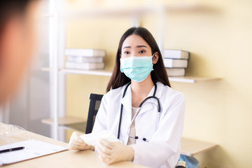  Medicine and health care concept.  Asian doctor is taking care patient woman in hospital.doctor or nurse wear protection mask checking and takecare infection people from covid-19 .