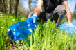 © Khaligo - Safe the planet, man volunteer hand picking up garbage in forest for clean planet, environmentally and ecology friendly