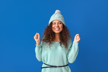 Wall Mural - Young woman in warm sweater on color background