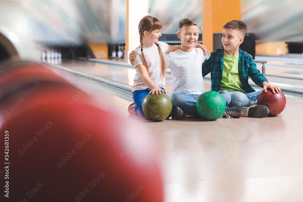 Little children playing bowling in club