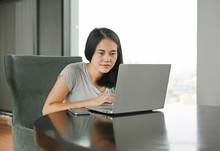 Asian woman using laptop computer working online at home. People during the introvert time at home from the epidemic