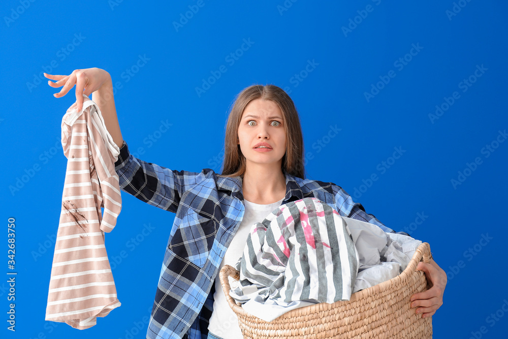 Troubled woman with dirty clothes on color background