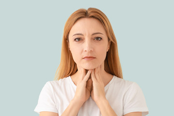 Canvas Print - woman with thyroid gland problem on light background