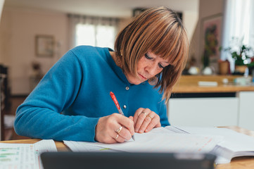 Anziana maestra/ lavoratrice lavora da casa in smart working. Distanza sociale e lavoro a distanza con il supporto della tecnologia 