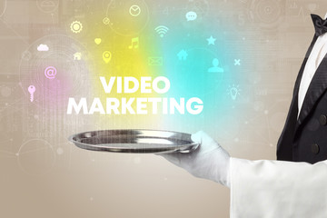 Waiter serving social networking with VIDEO MARKETING inscription, new media concept