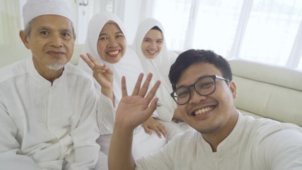 Wall Mural - Three generation Muslim family makes video call