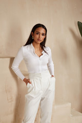 Wall Mural - Beautiful sexy brunette woman tanned skin face cosmetic makeup wear white suit pants for date walk office fashion clothes style collection interior room  sand color safari summer casual.