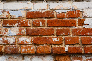 The texture of an orange brick wall with white paint. Brick background and white paint frame