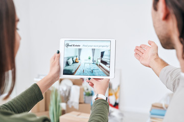 Poster - Young woman holding touchpad with advertisement of new real estate on screen