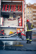 © luckybusiness - Fire truck with fire fighting equipment.Man firefighter in uniform.
