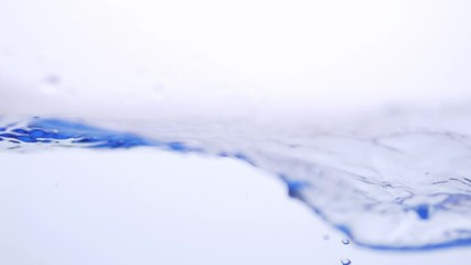 Wall Mural - Water splash surface filling the frame with the water drop and waving liquid with an air bubble on a white background. Slow motion 1080p 23.98fps