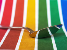 Spoon With Reflection Of Rainbow Colored Background