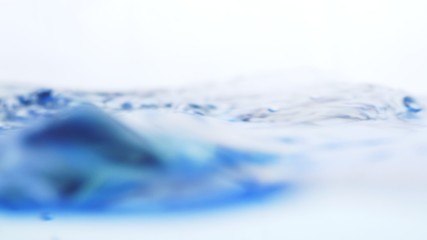 Wall Mural - Soft blur focus of Abstract water splash surface filling the frame with the water drop and waving liquid with an air bubble on a white background and copy space.