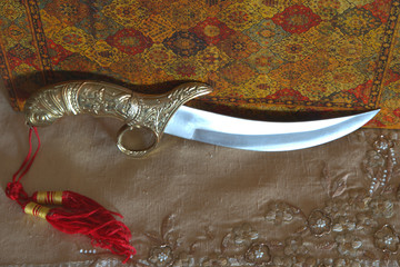 
Arabic knife in Indian tablecloth and leather book