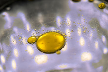 Oil Drops On Slightly Soapy Water In Macro View