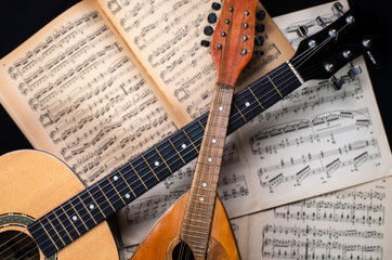 Wall Mural - Mandolin and guitar with old blurred sheet music books in the background.   .