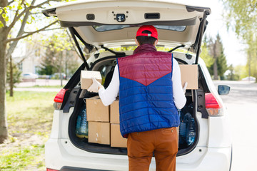 Sticker - Delivery man holding paper bag with food near the car, food delivery man in protective mask