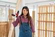 © godji10 - Portrait of Asian handywoman holding a power drill in her hands and standing in workshop. A Confident girl working as a carpenter. DIY Crafts and Hobbies concept.